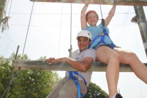 Male and female P-TECH students in climbing gear at the ropes course of HVCC