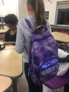 Student models backpack with sewn in LED lights