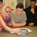 Students examining a piece of equipment at Simmons Machine Tool