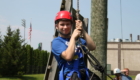 Male student in helmet and harness as he prepares for the ropes course