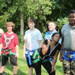 Students in harnesses smile for the camera