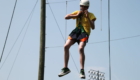 Male student in helmet and harness suspended in the air