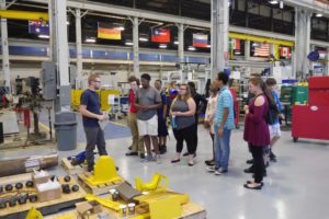 Students at Simmons Machine Tool Company listening to a tour guide 