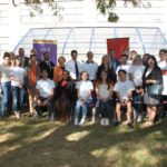 Group photo of press conference guests in front of greenhouse