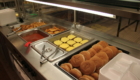 Hot food line with cheeseburgers and fries