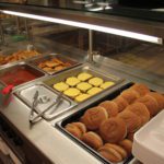 Hot food line with cheeseburgers and fries