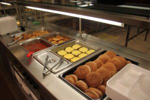 Hot food line with cheeseburgers and fries