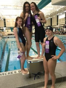 4 female swimmers holding ribbons