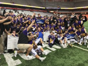 Entire Troy football and coaches pose for a photo on the field at the Carrier dome, most holding up two fingers