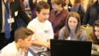 School 18 male students show conference attendees a project on a laptop