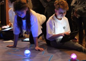 Male and female student demonstrate the use of robotics