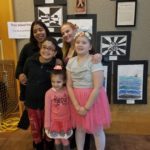Students standing in front of their artwork.