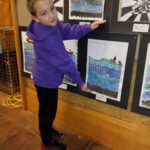 Students standing in front of their artwork.