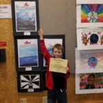 Students standing in front of their artwork.