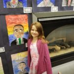 Students standing in front of their artwork.