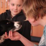 Girl and dog look into each others eyes