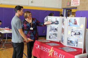 Woman at Questar III booth talking to a male student. 