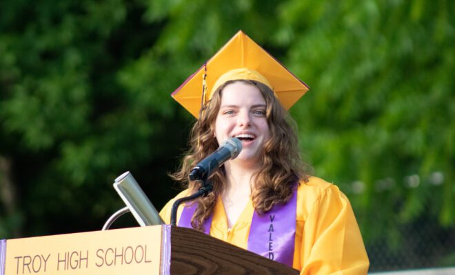 2021 students in yellow and purple cap and gown