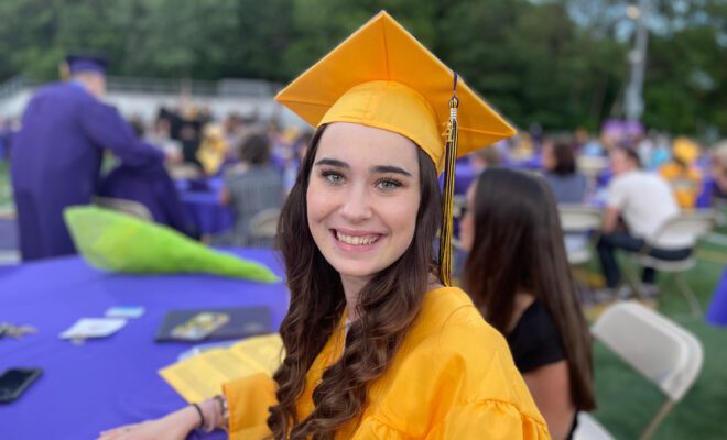 2021 students in yellow and purple cap and gown