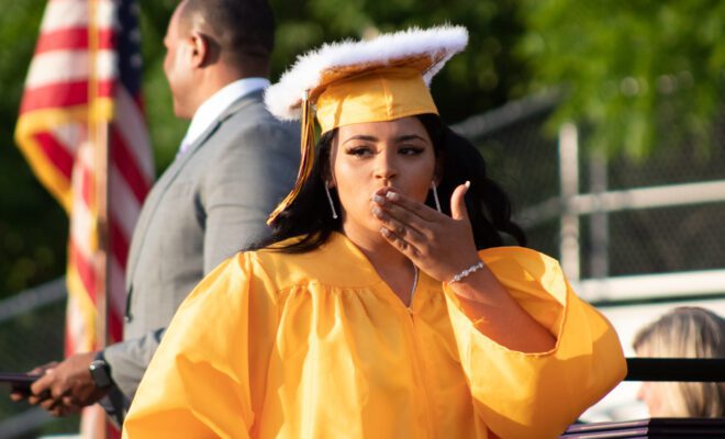 2021 students in yellow and purple cap and gown