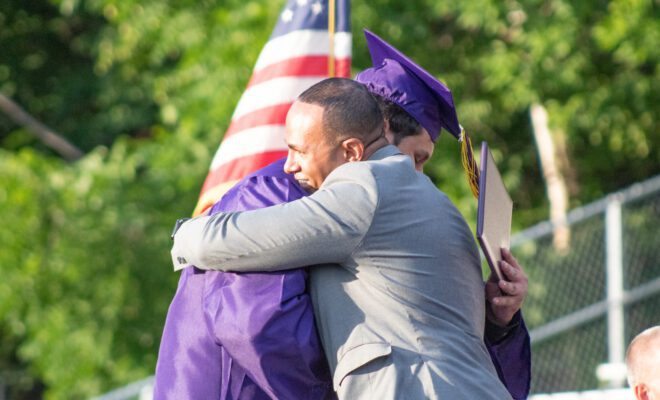 2021 students in yellow and purple cap and gown