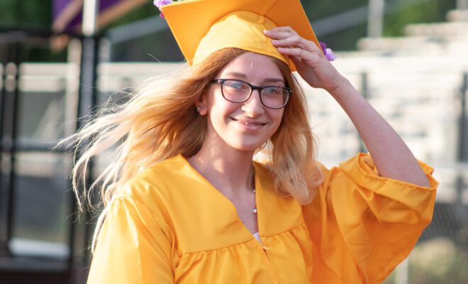 2021 students in yellow and purple cap and gown