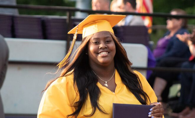 2021 students in yellow and purple cap and gown