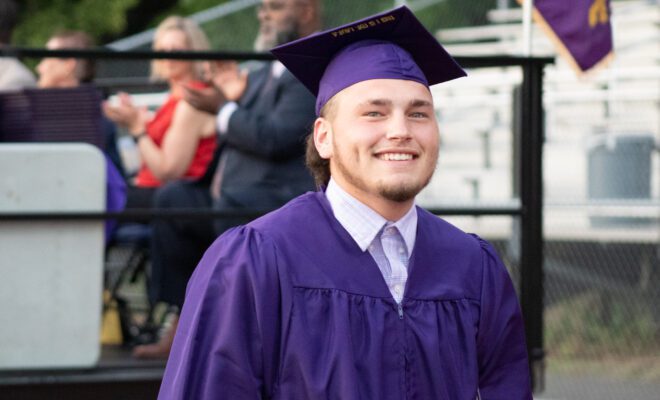 2021 students in yellow and purple cap and gown