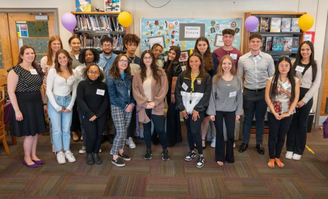 A group photo of 25 students in the troy high school library