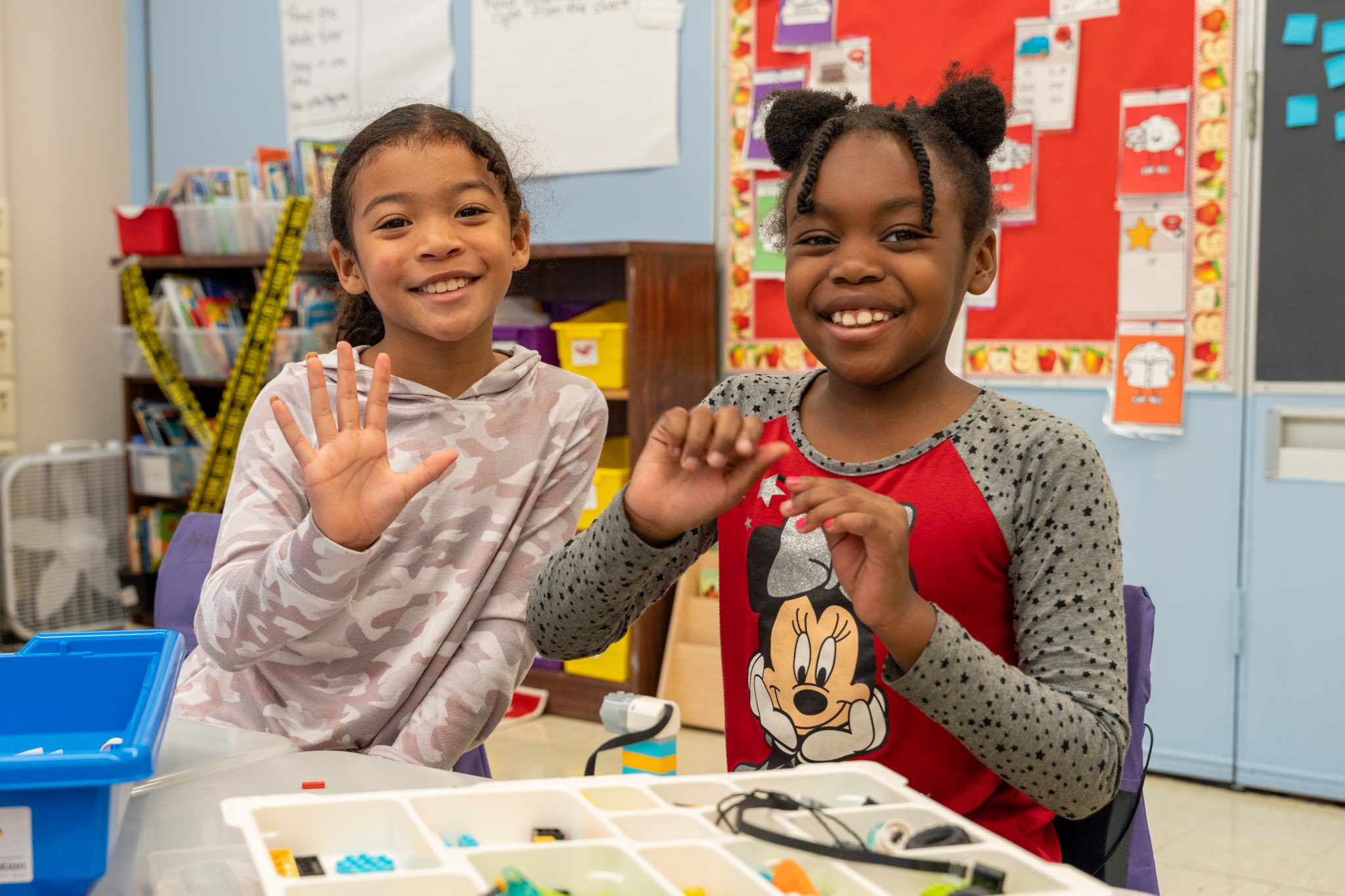 Boy smiling at camera while reading a book