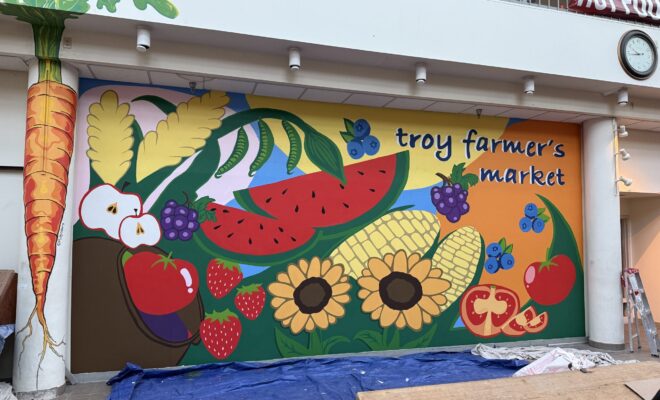 Completed vibrant mural at Troy Farmer's Market featuring colorful fruits, vegetables, and 'troy farmer's market' text