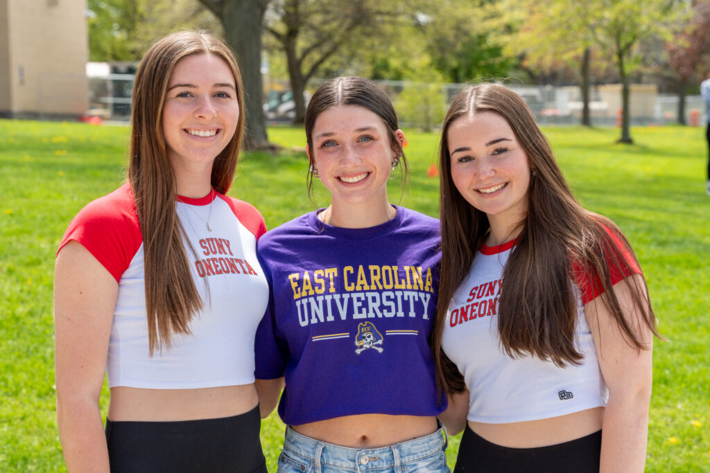 Three Troy High School seniors pose in SUNY Oneonta and East Carolina University shirts during Decision Day.