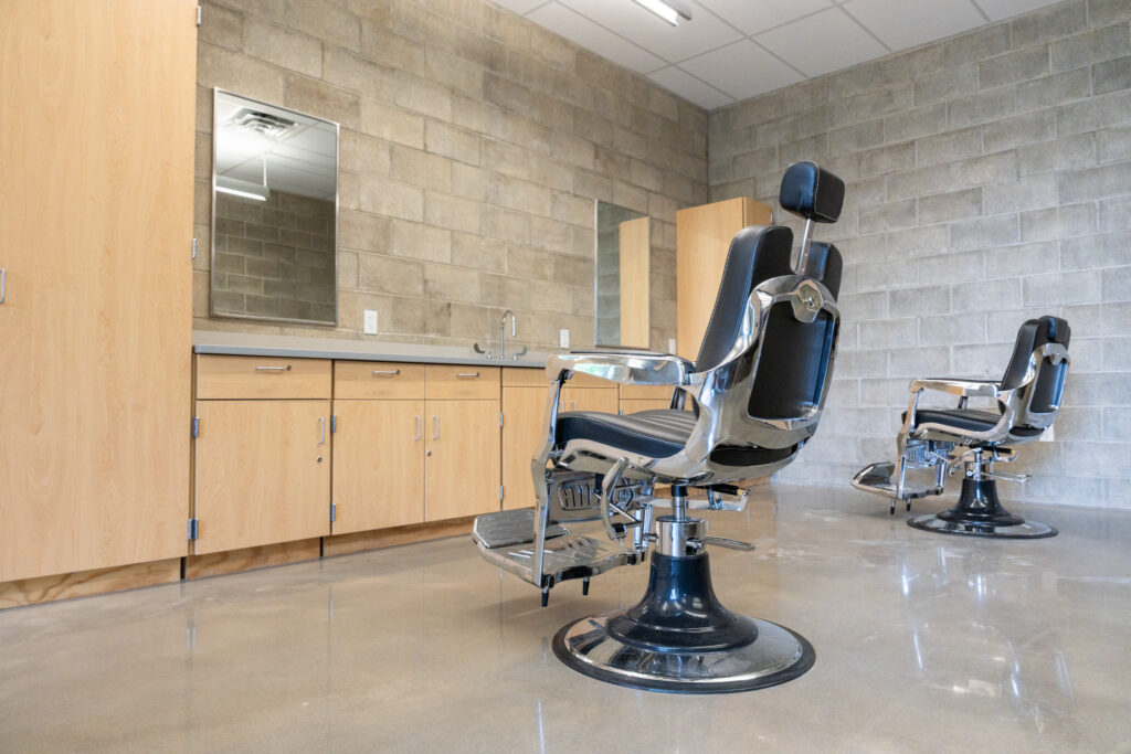 a barbershop classroom with two chairs, a counter and mirrors
