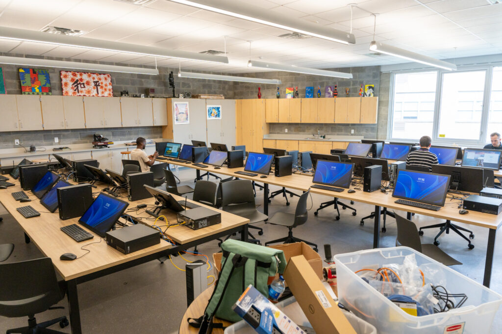 A digital art classroom with three rows of computers with touch screen tablets